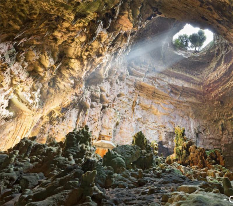 La Grotta di Castellana, un'ampia caverna con stalagmiti e luce naturale dall'alto.