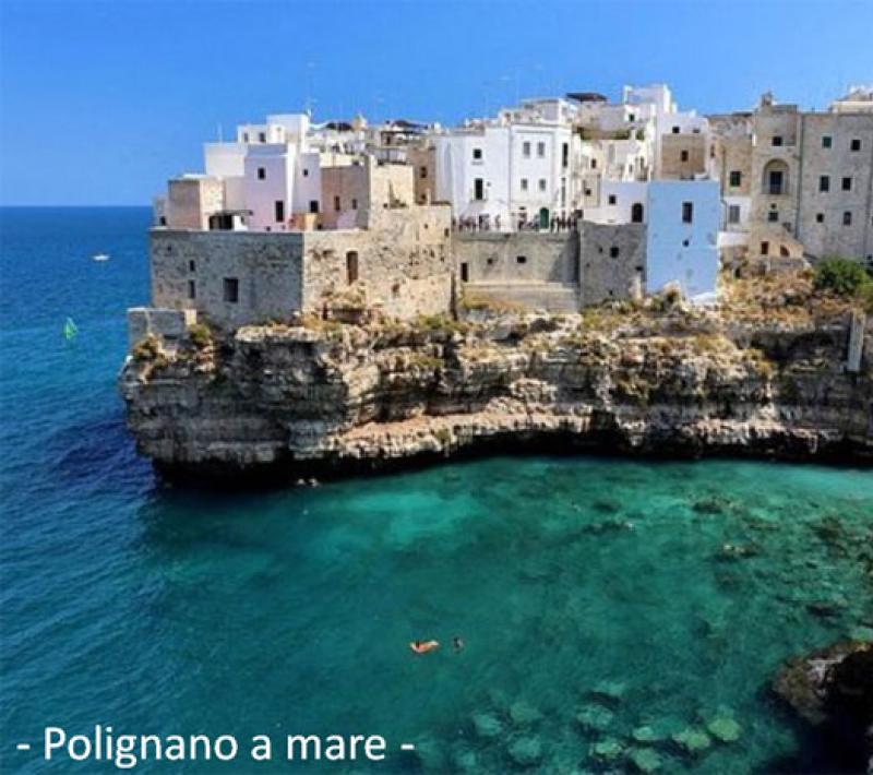 Affascinante borgo pugliese con case bianche su scogliere e mare cristallino.